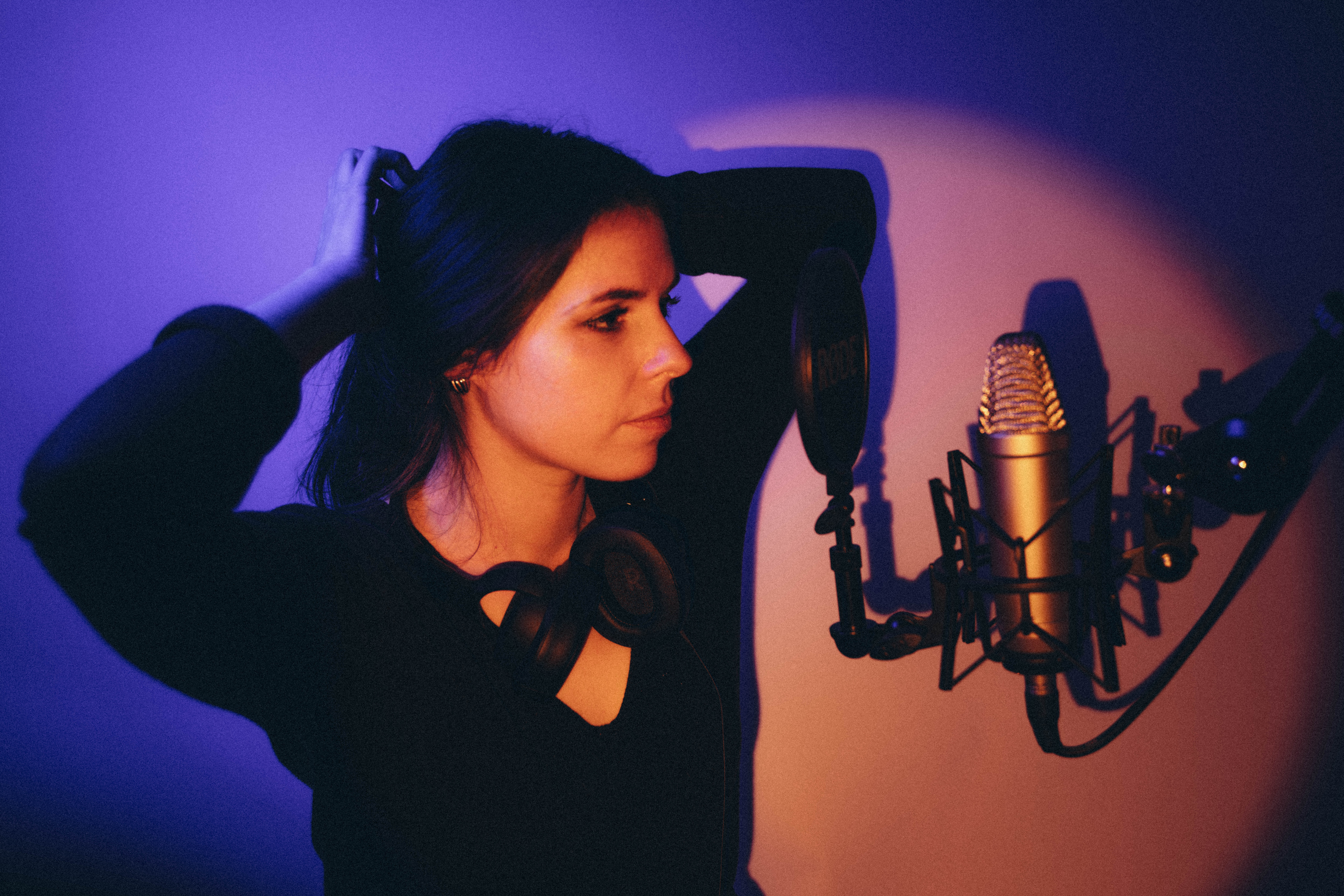 Comédienne voix off enregistrant au casque dans un home-studio équipé